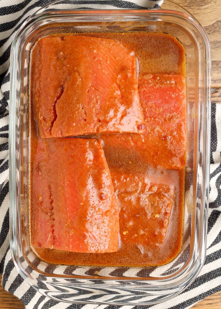 salmon filets in marinade in a glass container