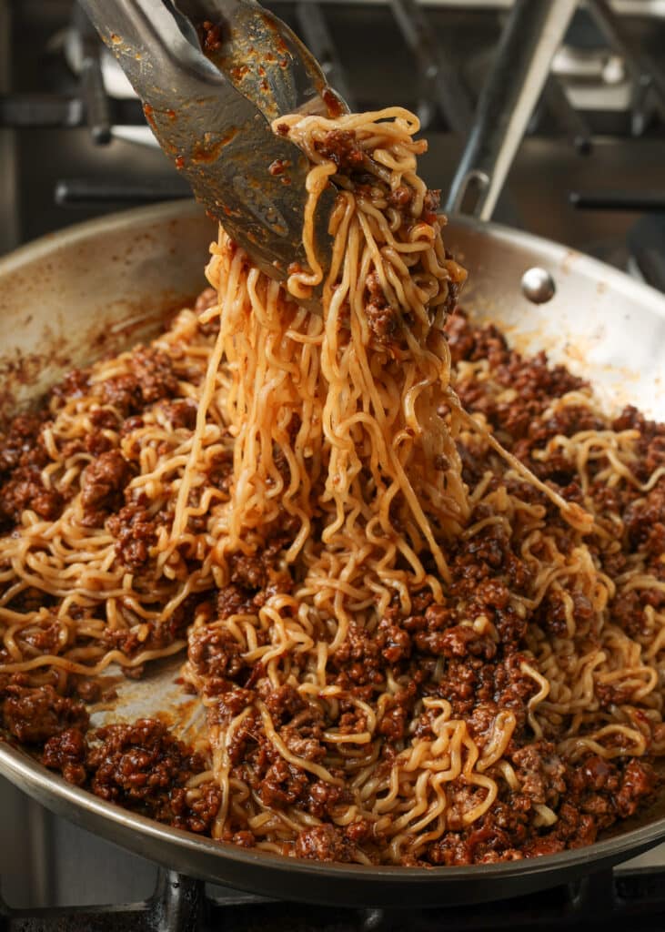 Korean beef noodles in a pan with tongs