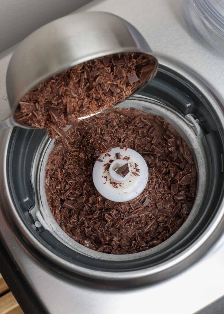 pour shot of chocolate chips being added to ice cream in machine