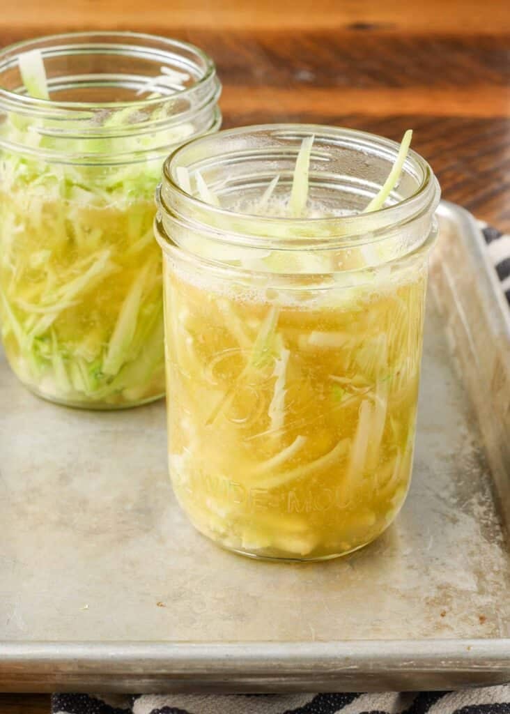 pickled broccoli stems in a jar of brine