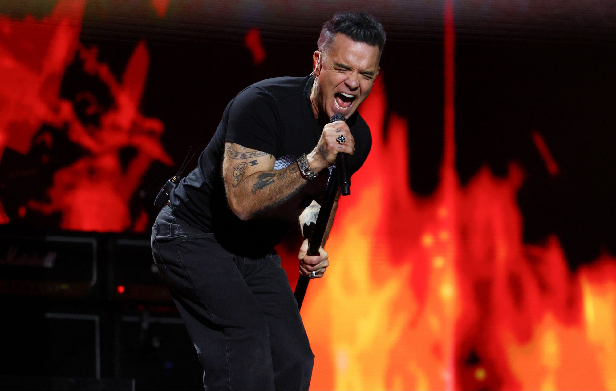 Robbie Williams performs on stage in 2026