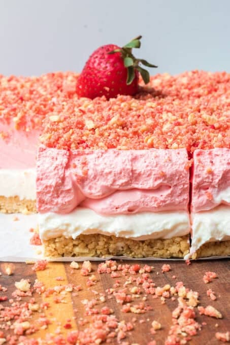 A strawberry on top of a creamy strawberry gelatin dessert.