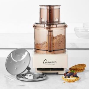 Cuisinart 50th Anniversary Edition food processor with a brown transparent hopper on a white kitchen counter, pastries nearby.