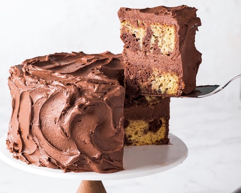 Peanut Butter-Chocolate Marble Cake sliced lifting slice on white cake stand