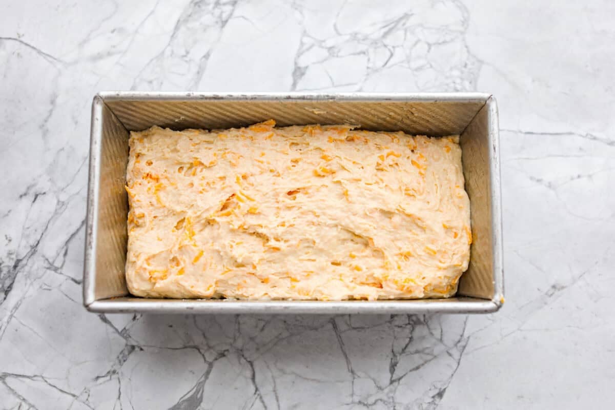 Cheddar bay biscuit bread batter added to the loaf pan. 