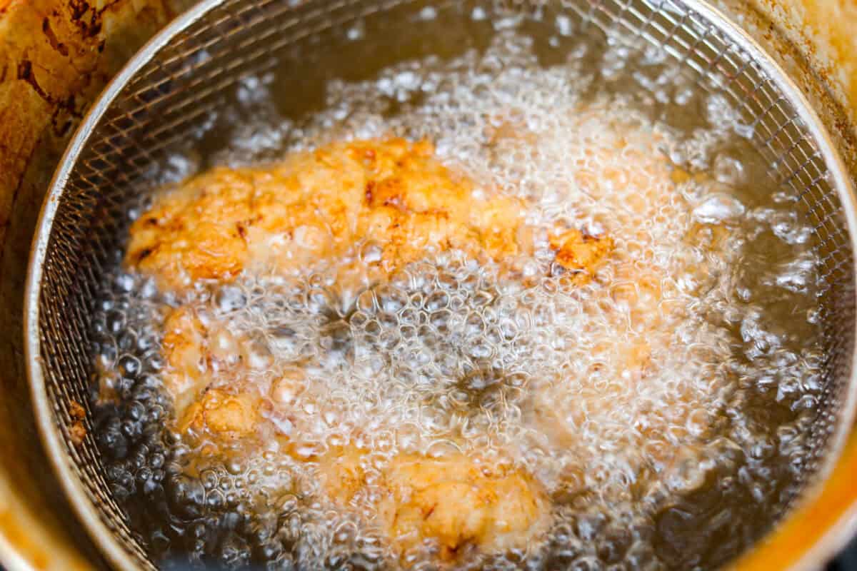 Raising Cane's chicken frying in a fryer.