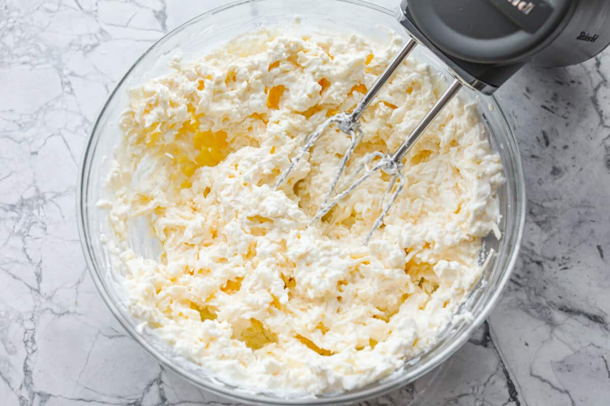 Cream cheese, cottage cheese, sour cream, mozzarella, and parmesan mixed together in a mixing bowl. 