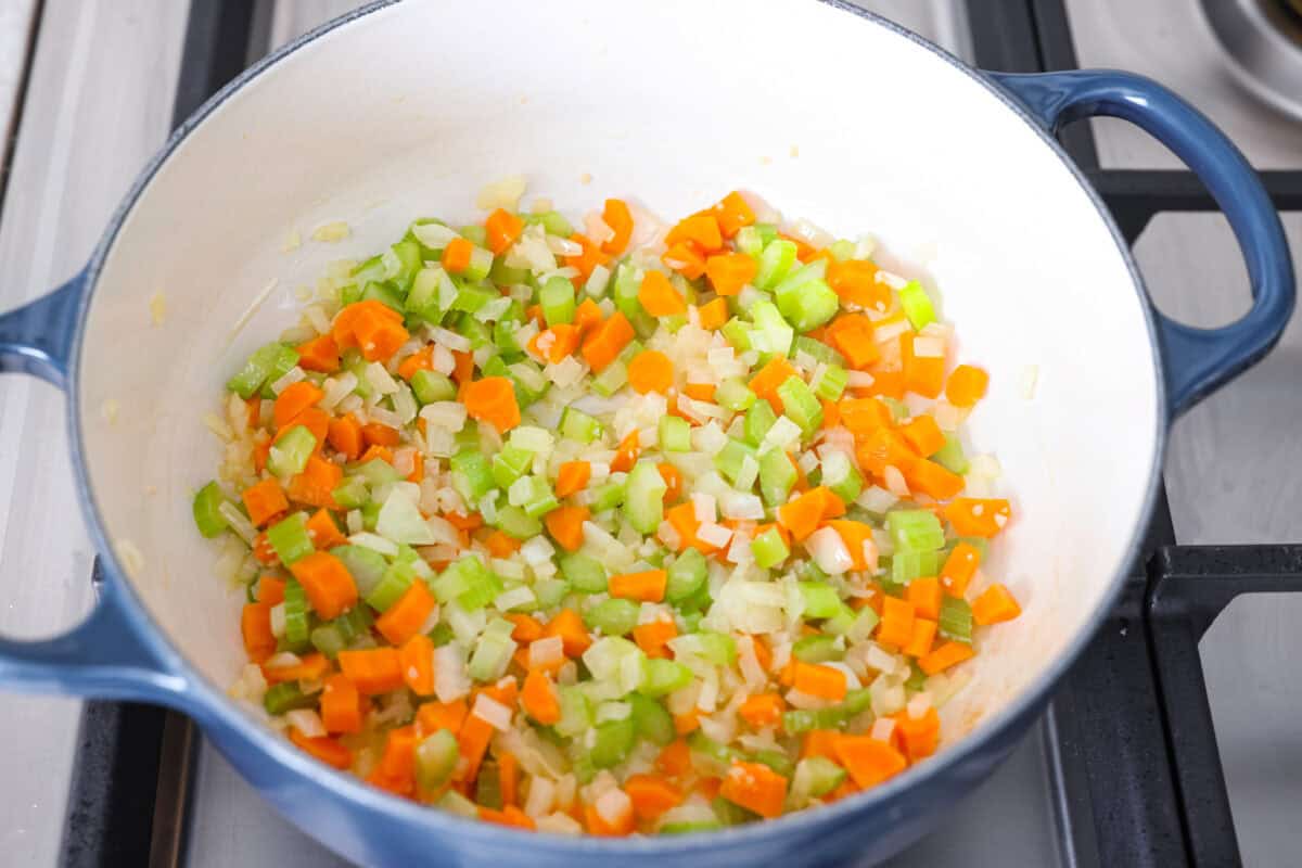 Pot with onion, carrot, and celery cooking in butter.