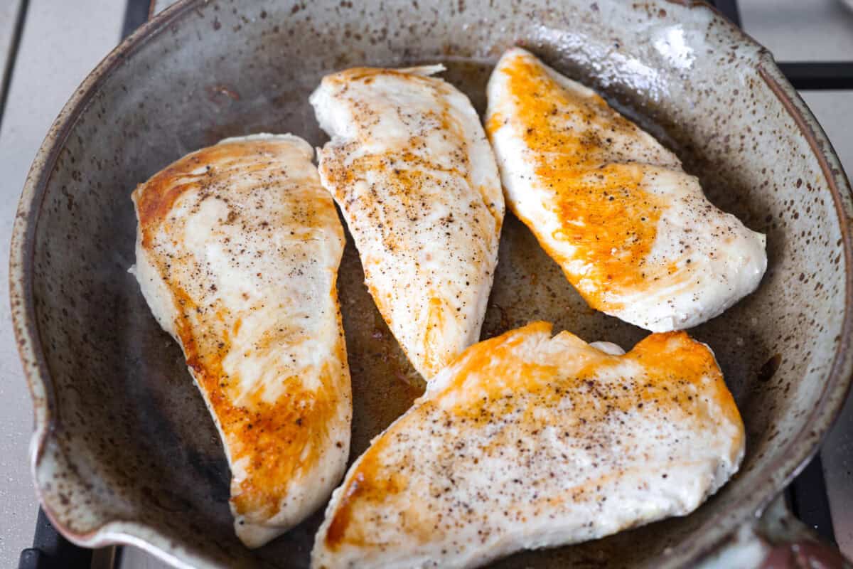 Chicken cooking in a skillet.