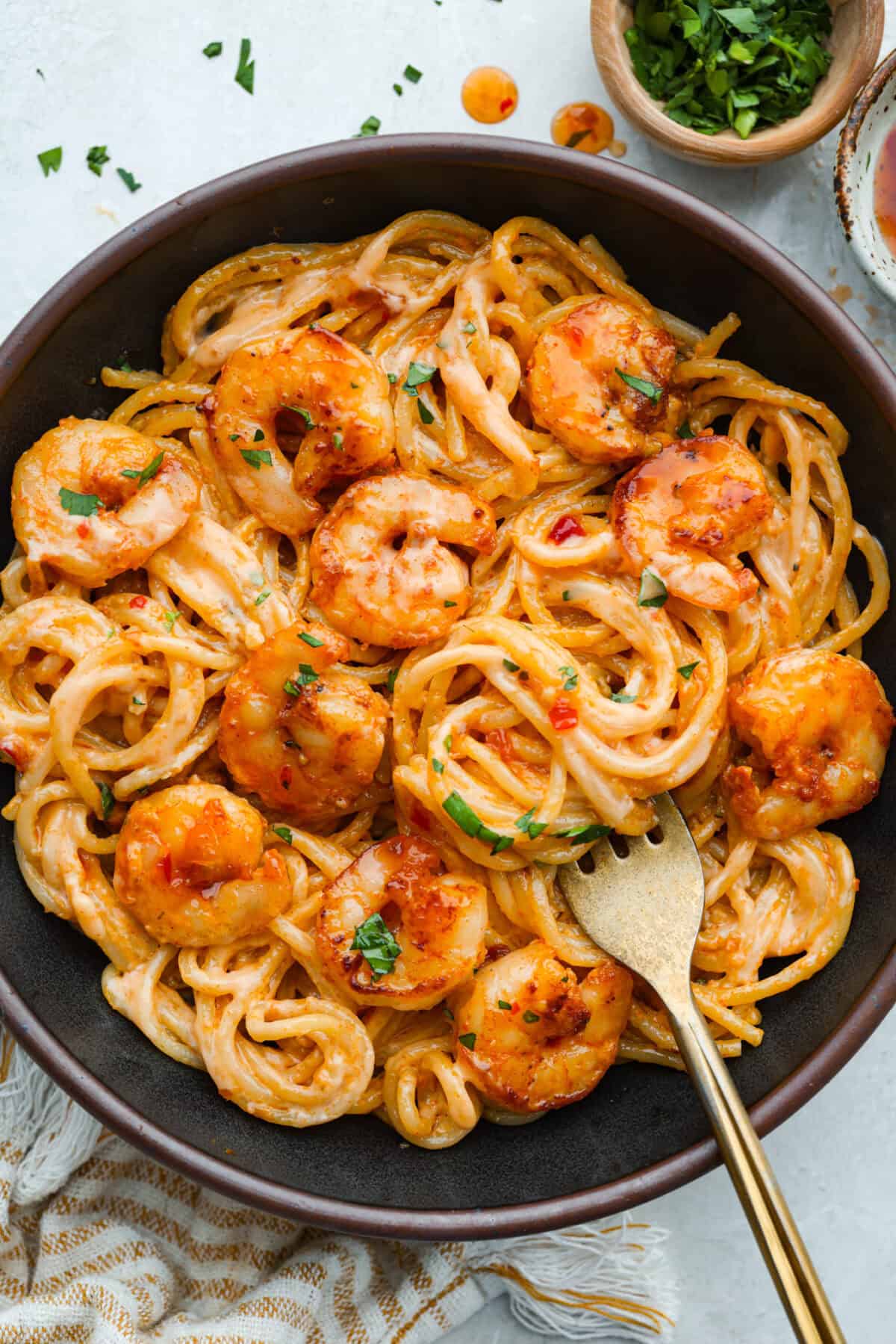 Plated bang bang shrimp pasta with gold spoon.
