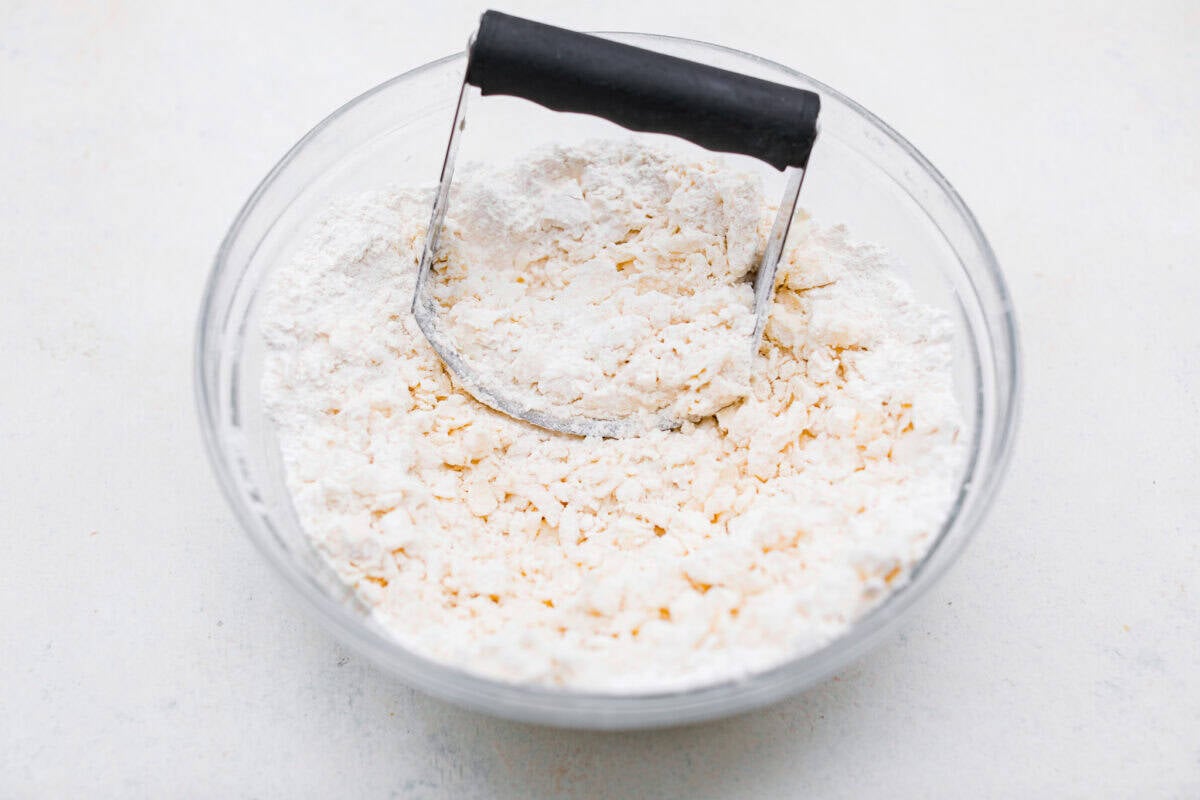 Crust ingredients in a bowl with a pastry blender.