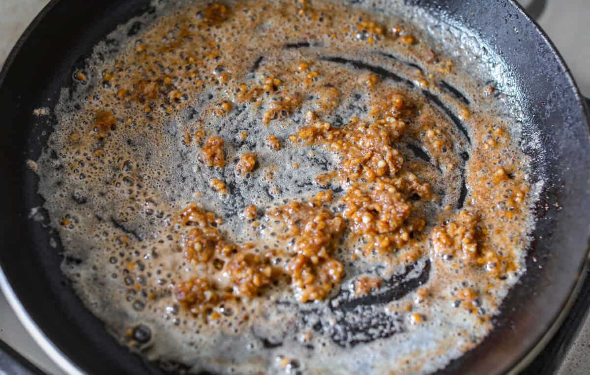 Butter and garlic added to the to scrape up any brown bits from the steak and to start the sauce. 
