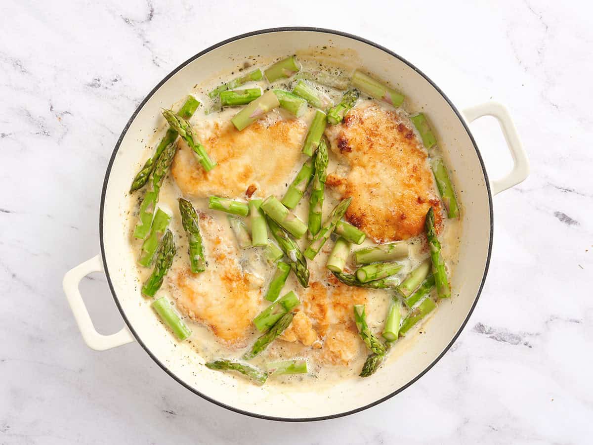 Creamy asparagus chicken in a skillet.