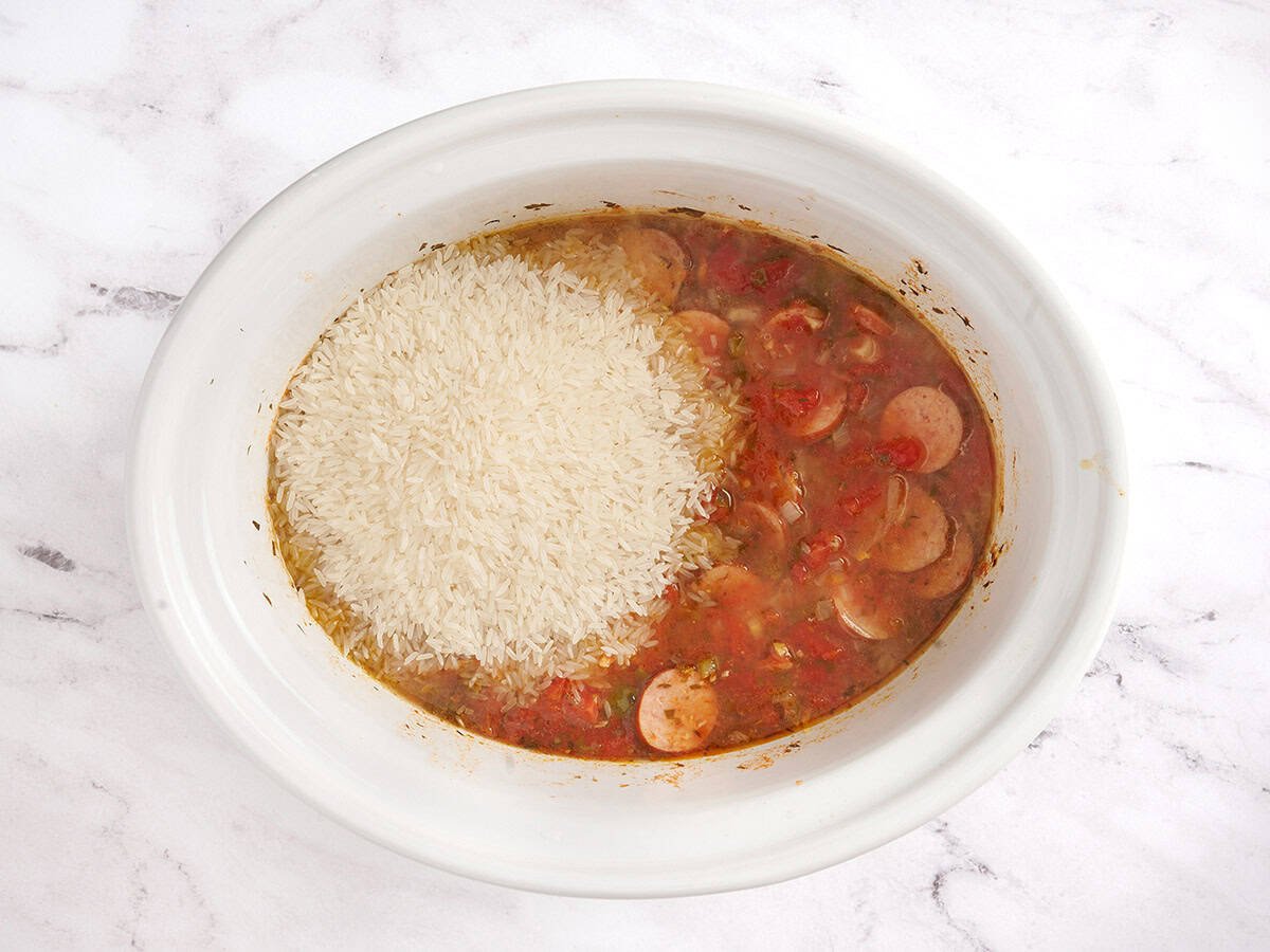 Adding rice to the crockpot. 