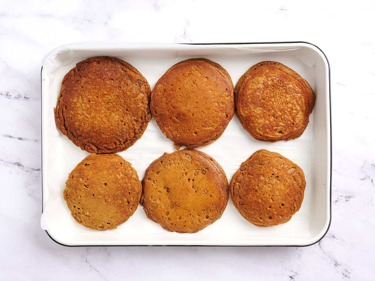 Six pancakes on a baking sheet.