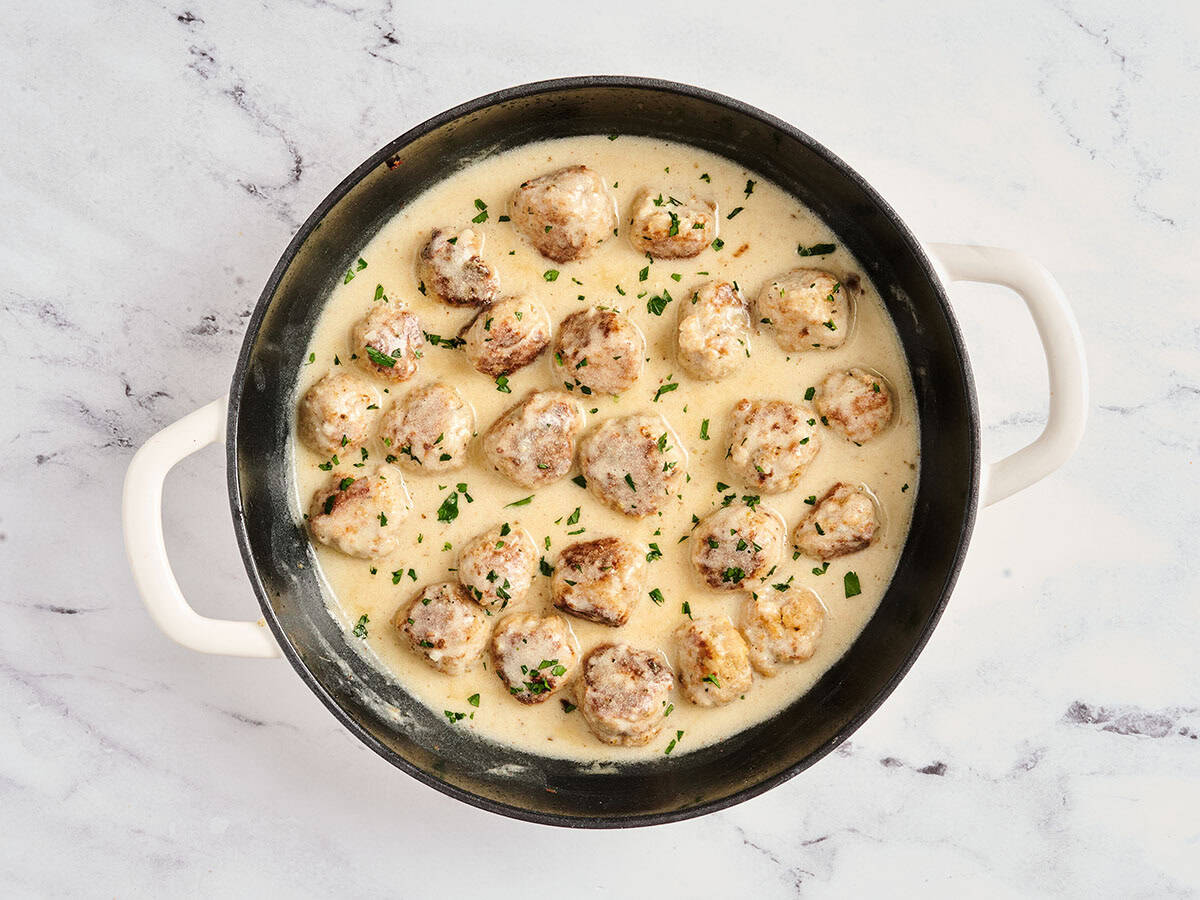 Finished creamy chicken meatballs in a skillet.