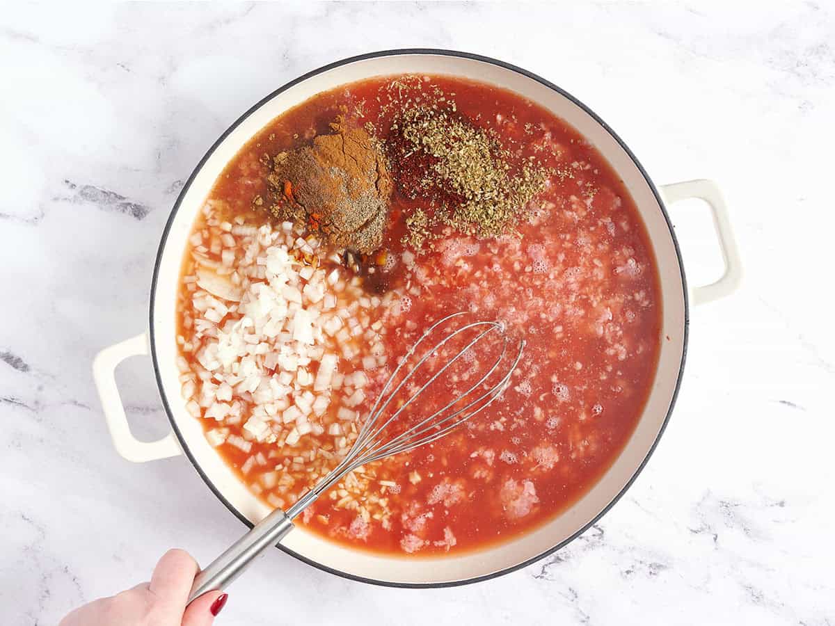 The ingredients to make skyline chili being whisked together in a pot.