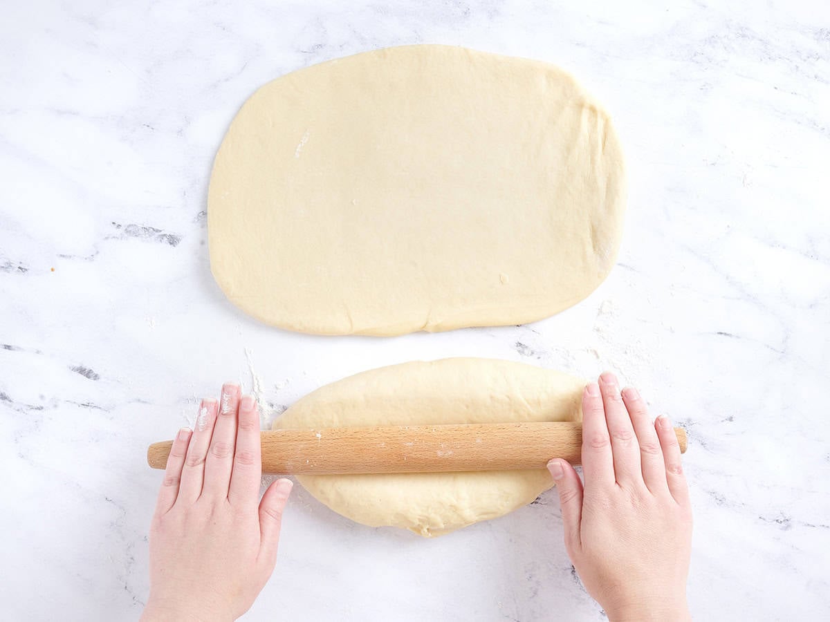 Rolling out the risen dough.