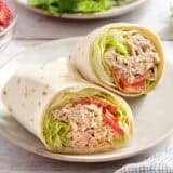 A tuna wrap sliced in half on a plate.