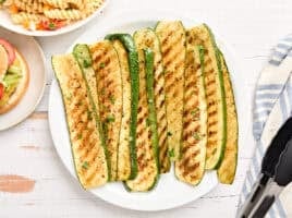 Overhead view of grilled zucchini slices on a plate.