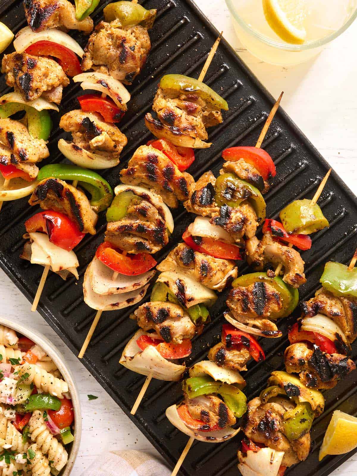 Overhead view of chicken kabobs on a grill.