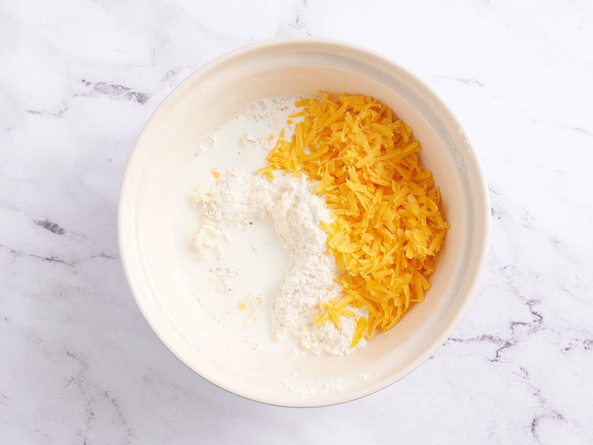 Milk and shredded cheese in a bowl.