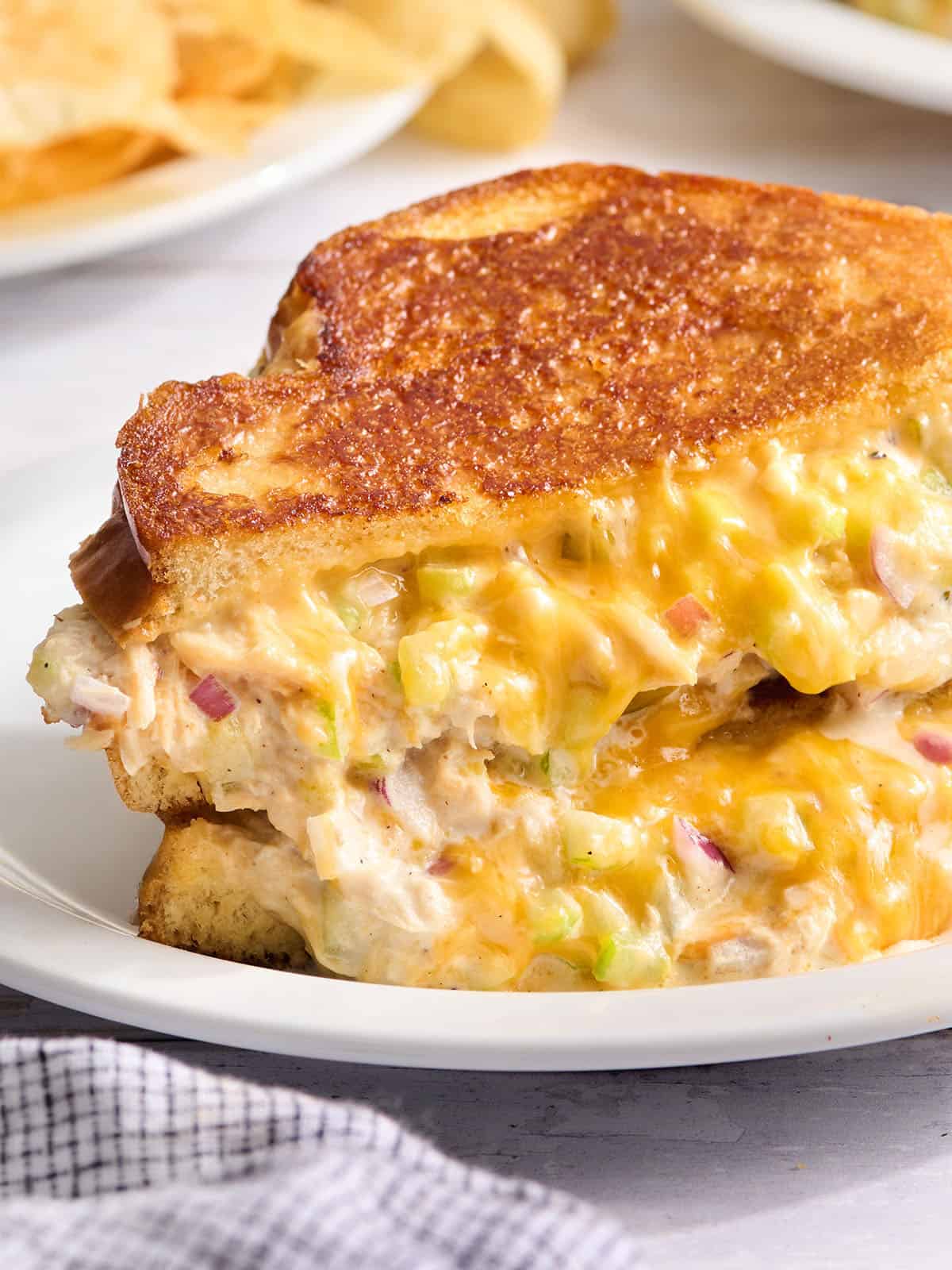 Classic tuna melt sandwich on a white plate.