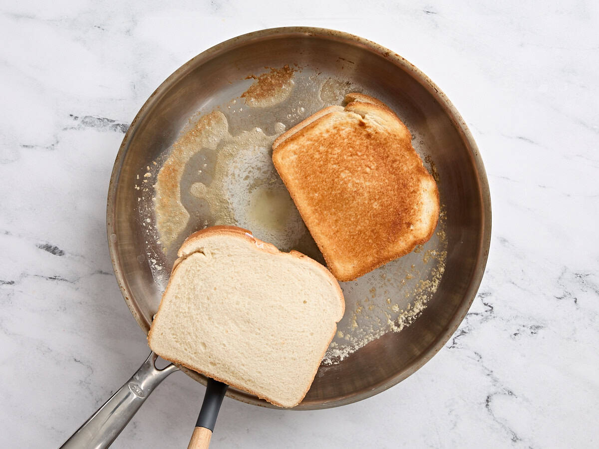 Toasting the tuna melt sandwiches in a frying pan.