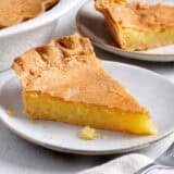 Side view of a slice of homemade chess pie on a plate.