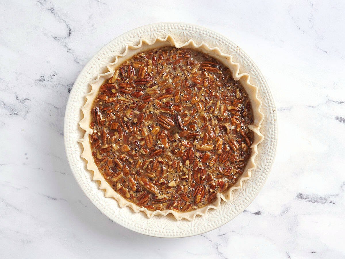 Pecan pie filling in a pie crust.