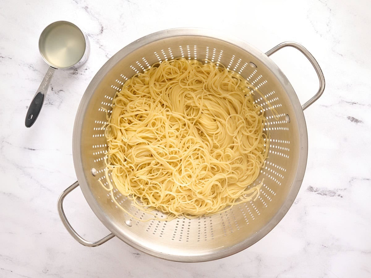 Cooked angel hair pasta in a skillet.