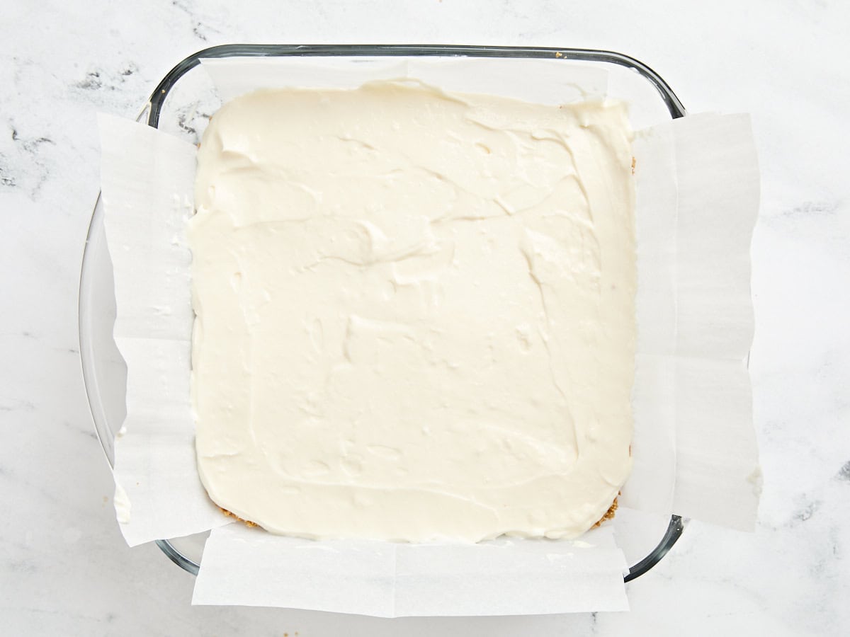 Cheesecake filling added to a baking dish.