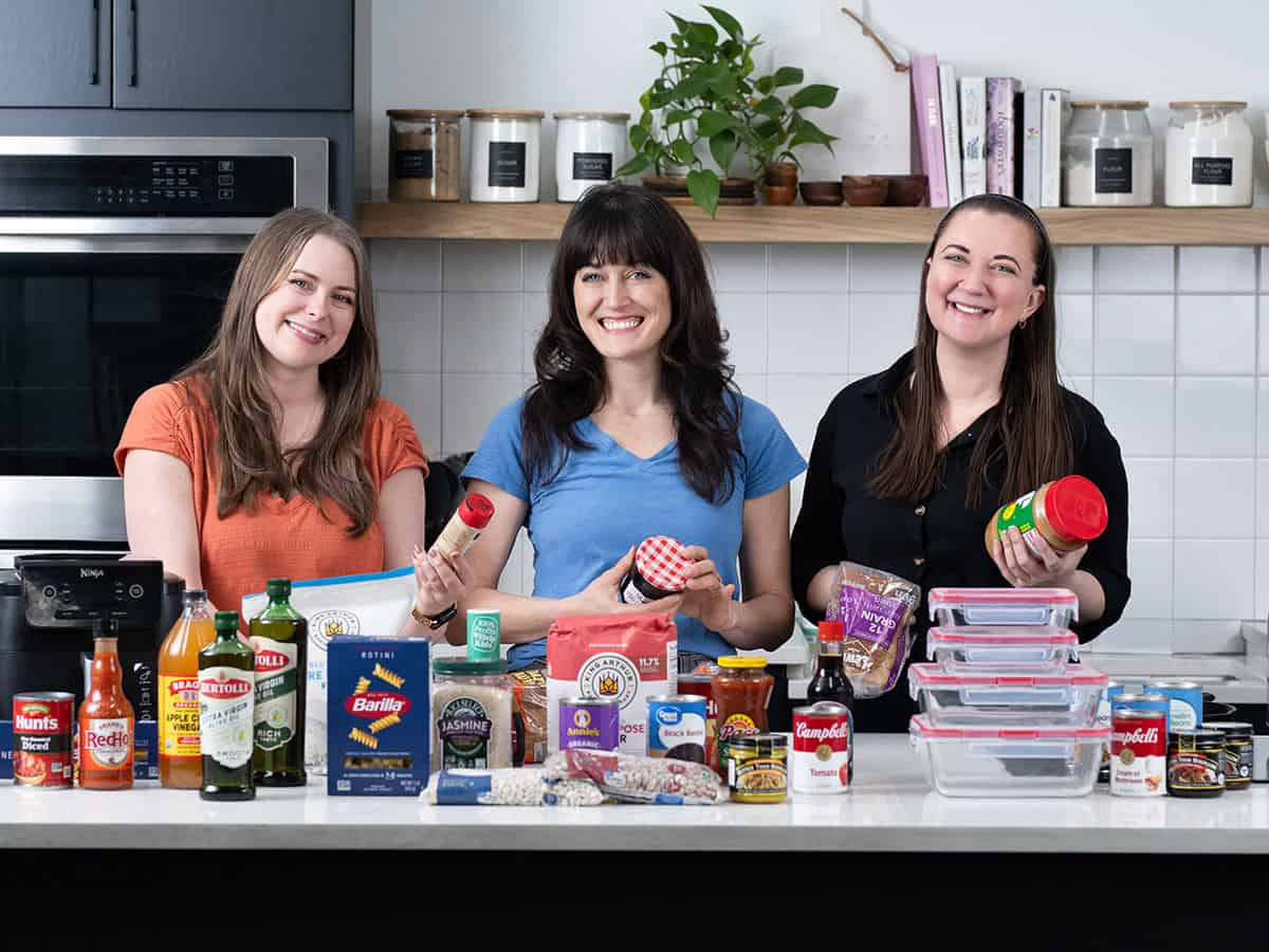 three woman posing with various brands of food