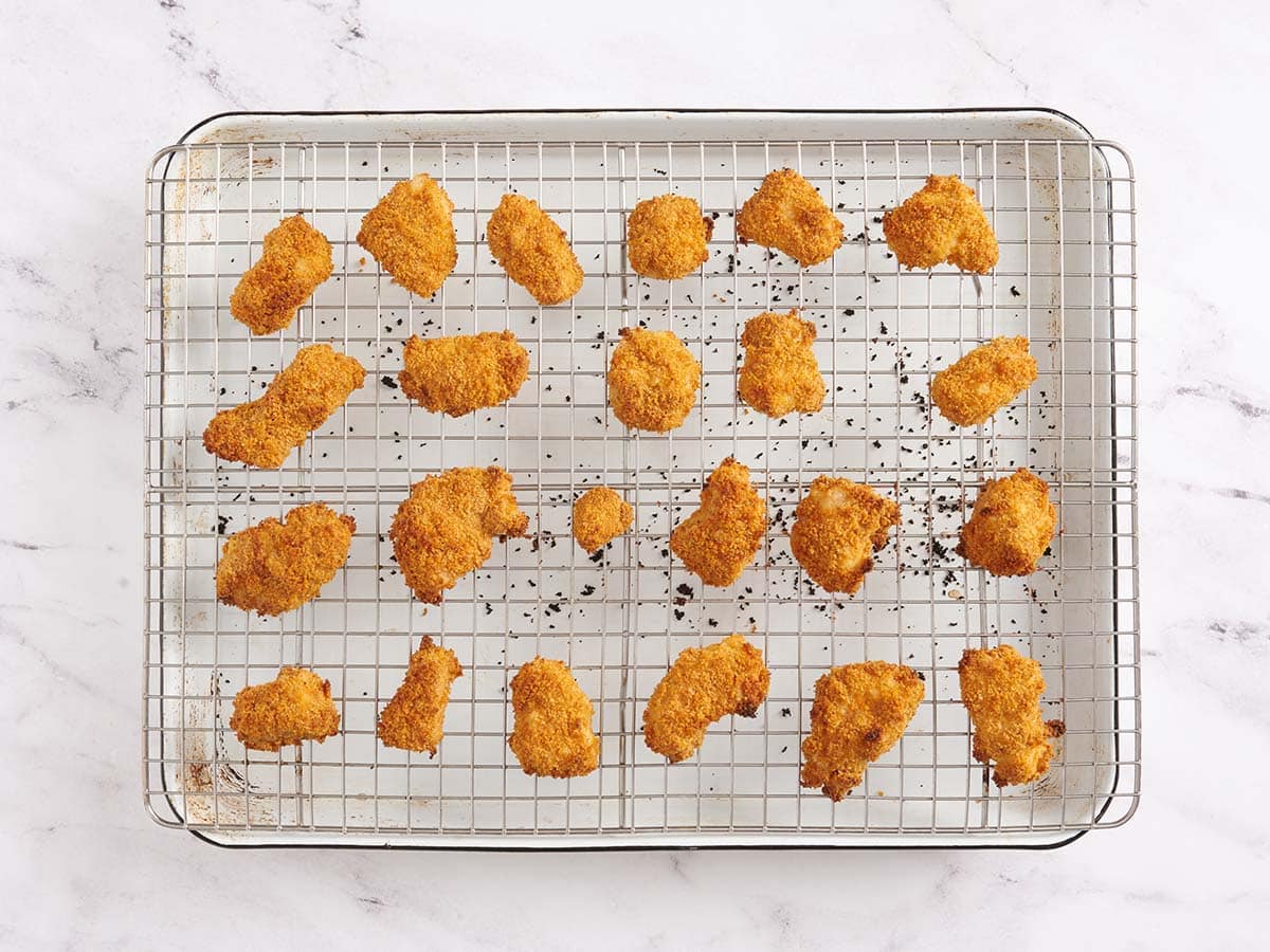 Finished homemade chicken nuggets on a wire rack after baking.