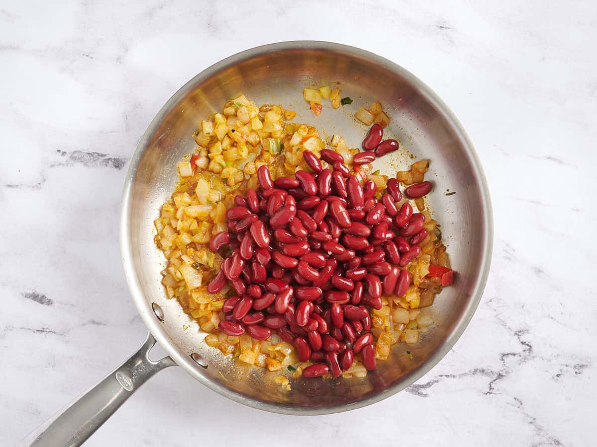 Mixed veggies and kidney beans in a skillet.