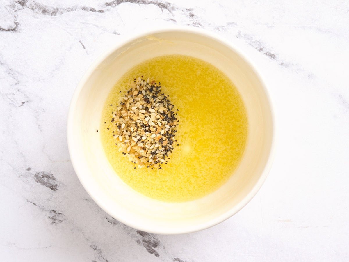 A bowl of melted butter with seasonings added.