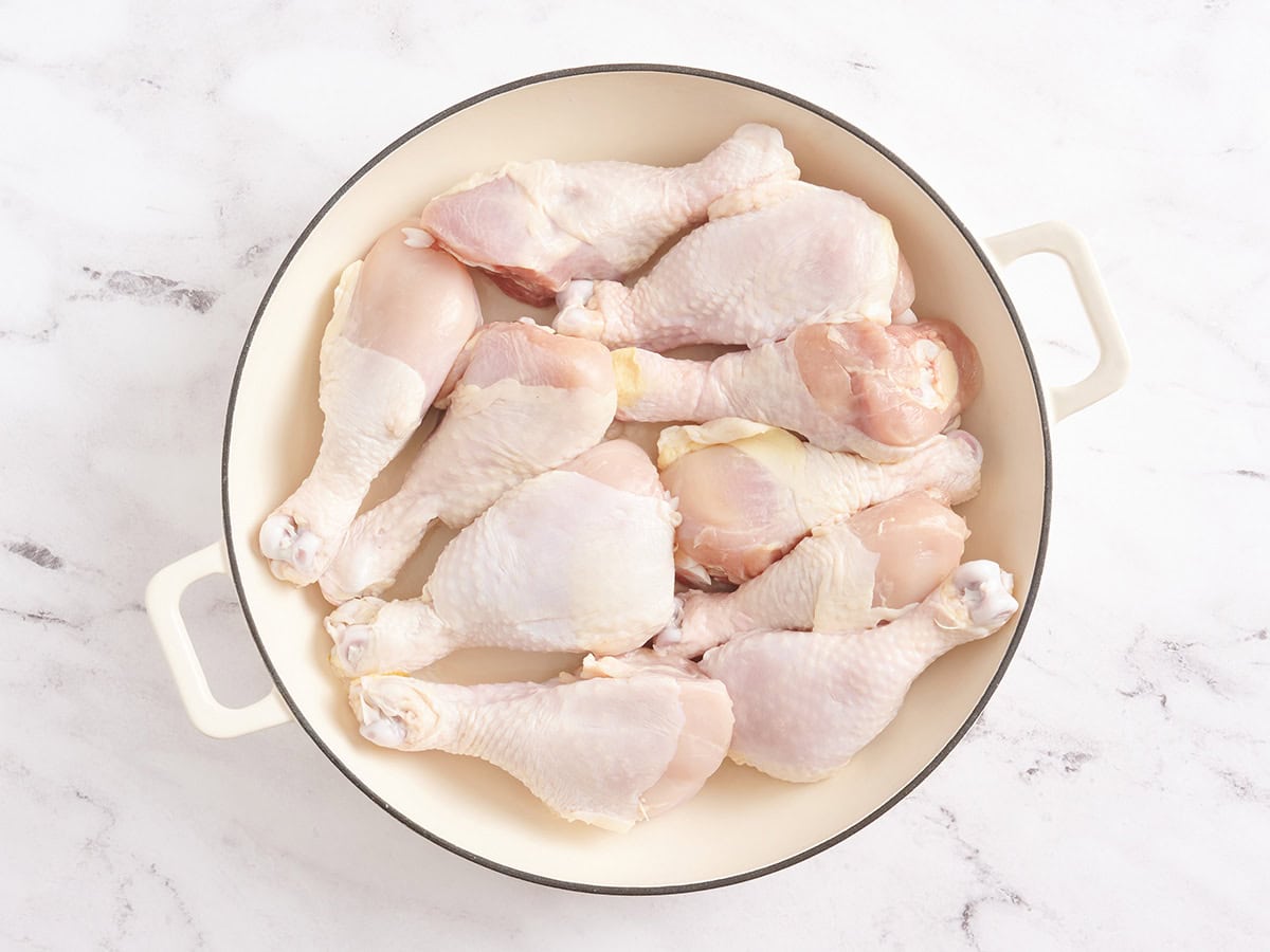Chicken drumsticks in a large pot.