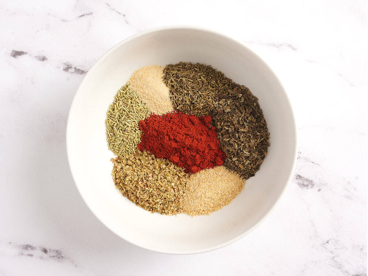 Herbs and spices for poultry seasoning in a bowl.