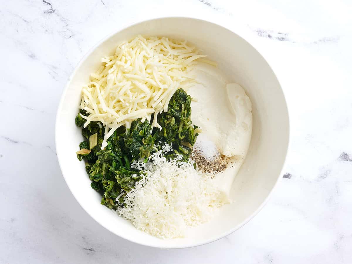 Shredded cheese, spinach, and ricotta in a bowl.