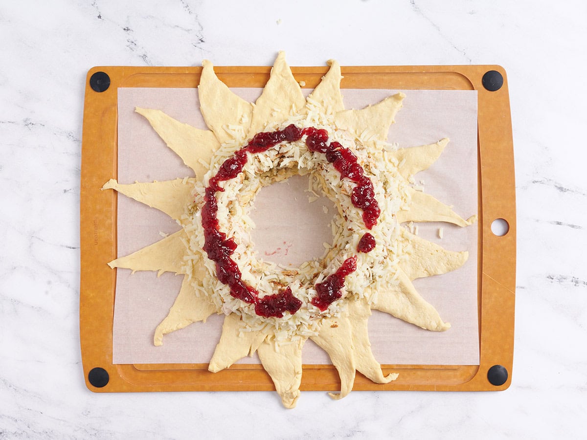 Adding cranberry sauce to the wreath. 