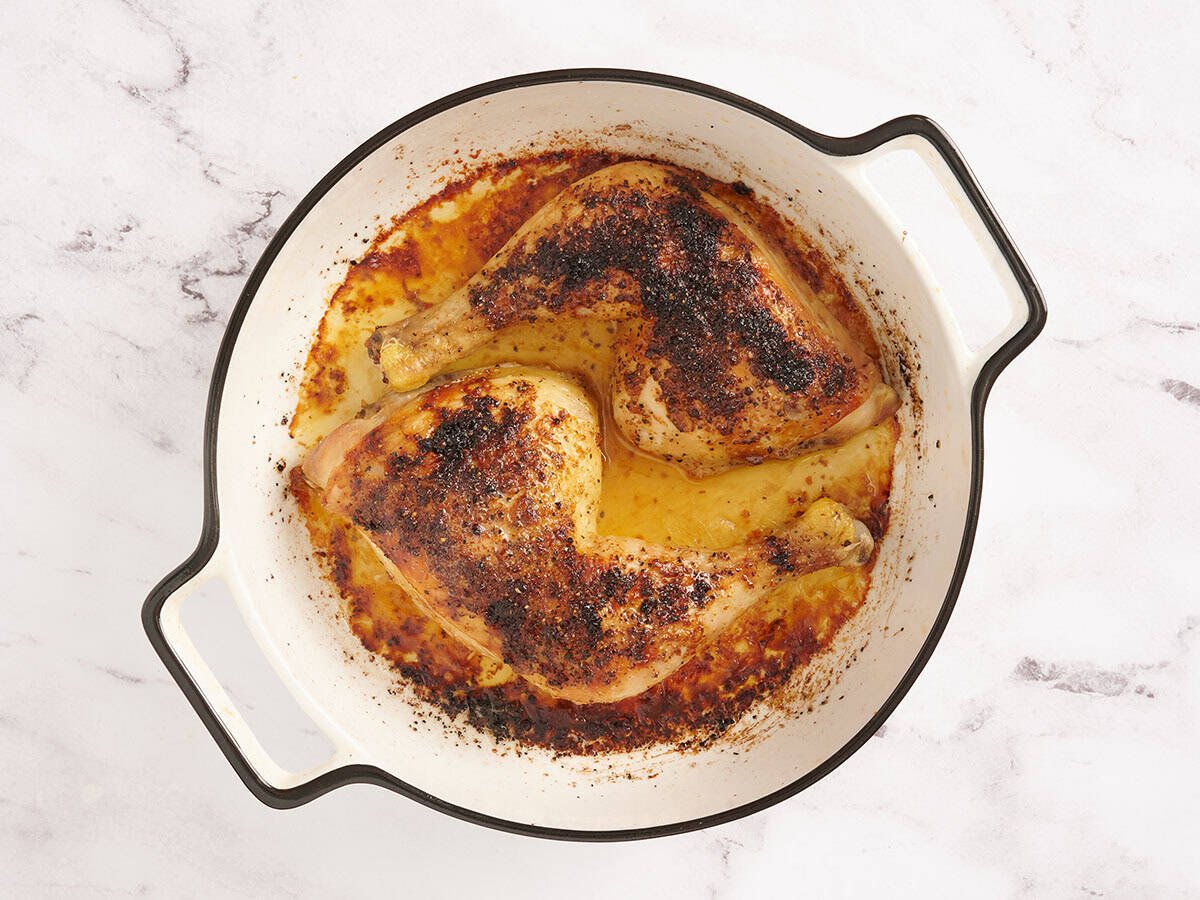 Finished oven roasted chicken legs in a baking dish.