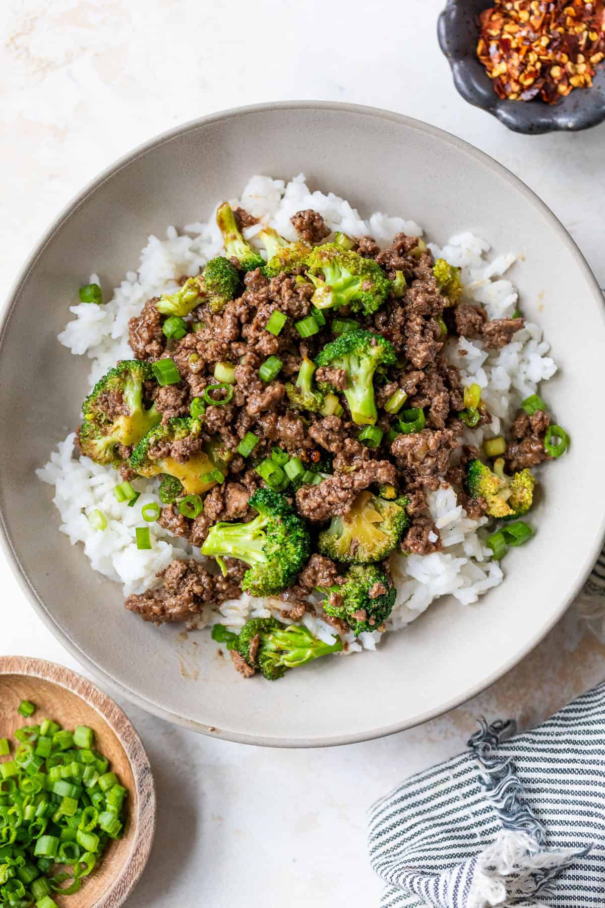 Bowl of rice topped with ground beef and broccoli stir fry.