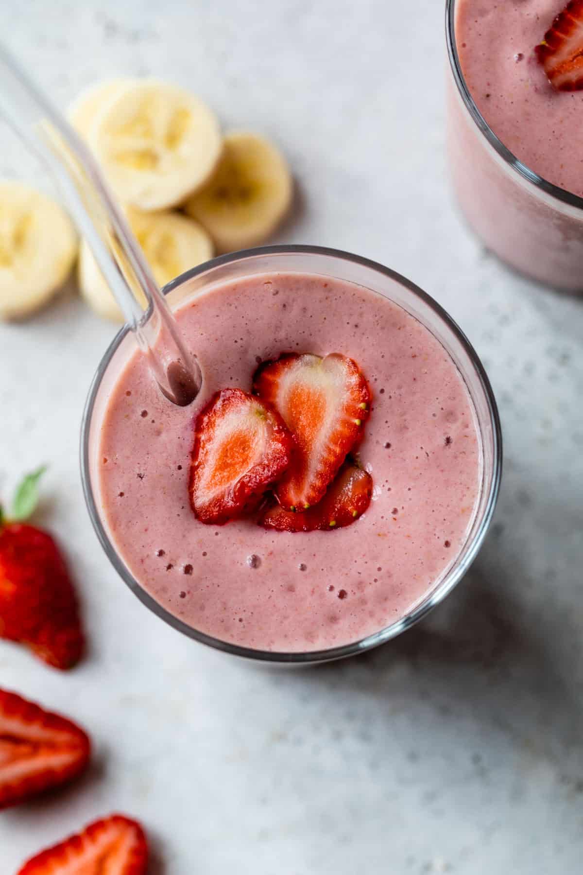 Top down view of creamy strawberry banana smoothie in glass