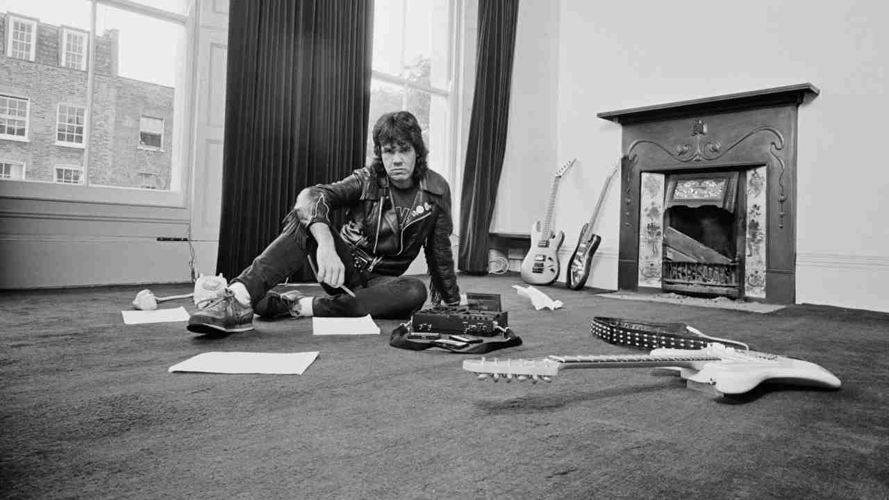 Gary Moore posing for a photograph in an empty room in  1984